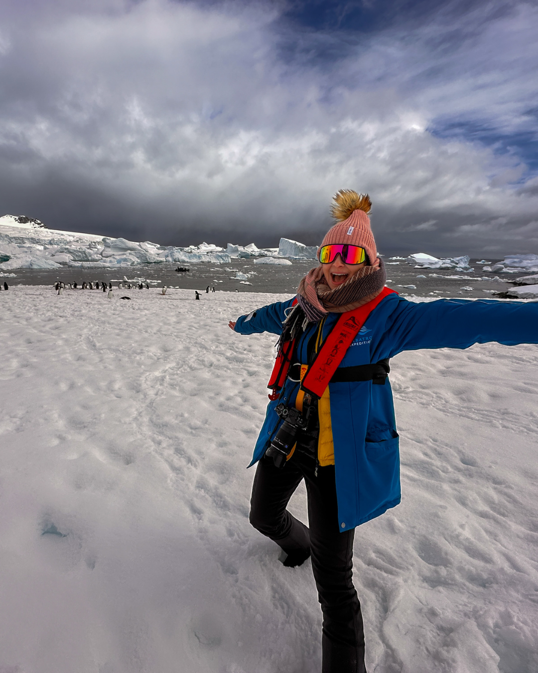 photo of alice ford with camera around her neck on ice with penguins