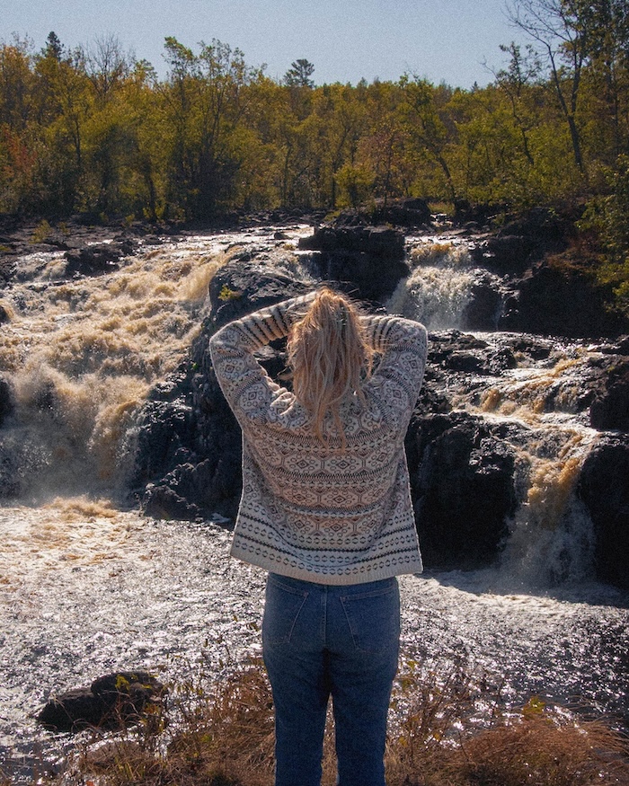 outdoor creator at a waterfall staring at water