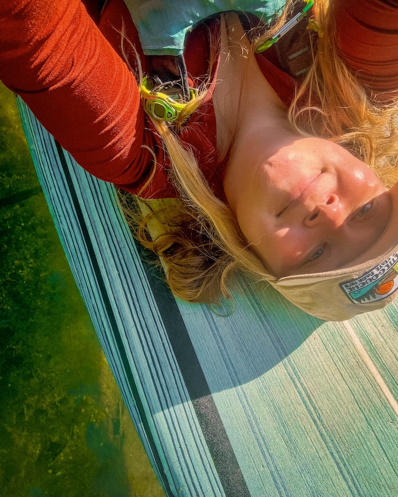 paddle boarded creator maddy marq looking at camera on a paddleboard